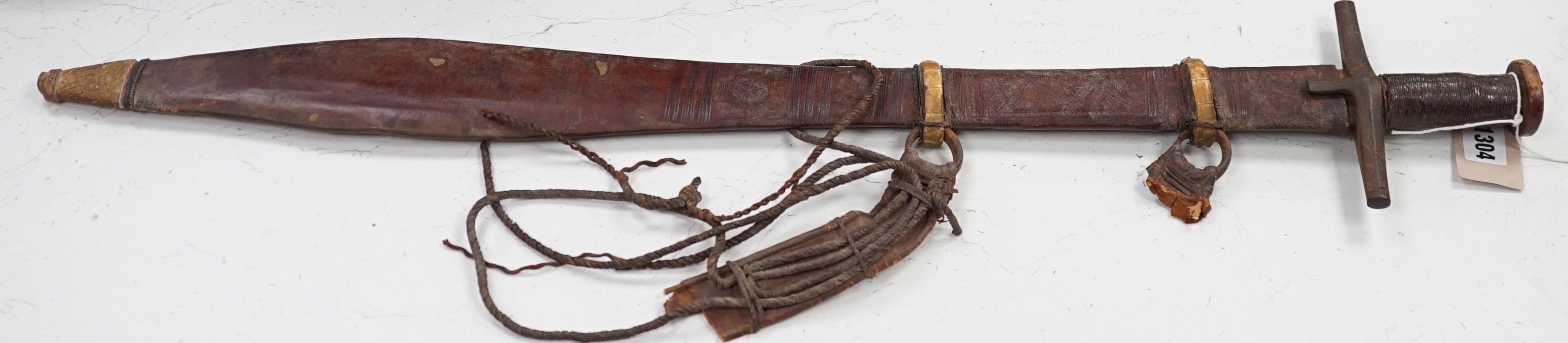 A Sudanese Kaskara sword with snake skin mounted leather scabbard, total length 79cm